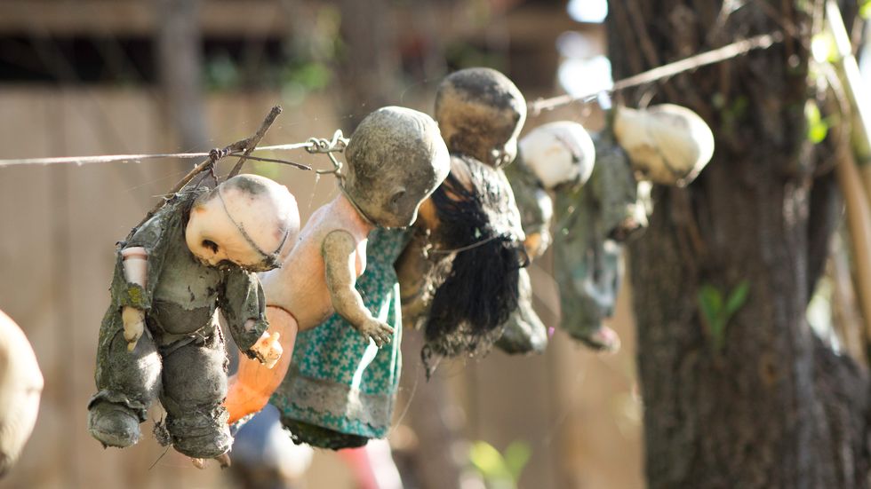 unas cuantas muñecas colgadas de una cuerda en xochimilco, méxico