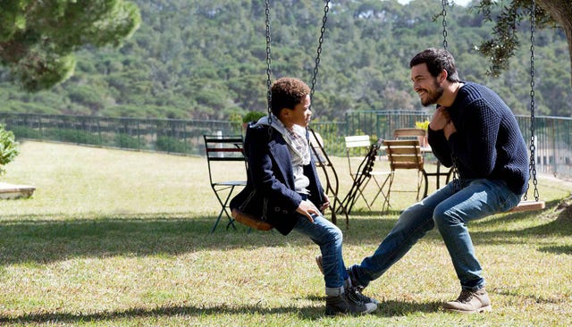 mario casas en un columpio con un niño negro
