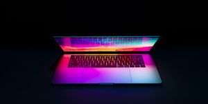 isolated high tech open laptop with abstract vibrant color screen on a dark background