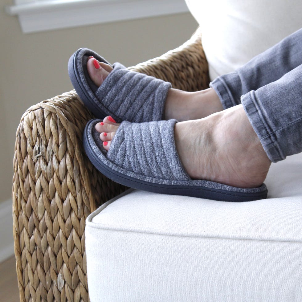 feet with isotoner slides on couch