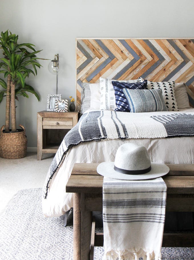 gray bedroom with headboard cut from planks of herringbone patterned wood