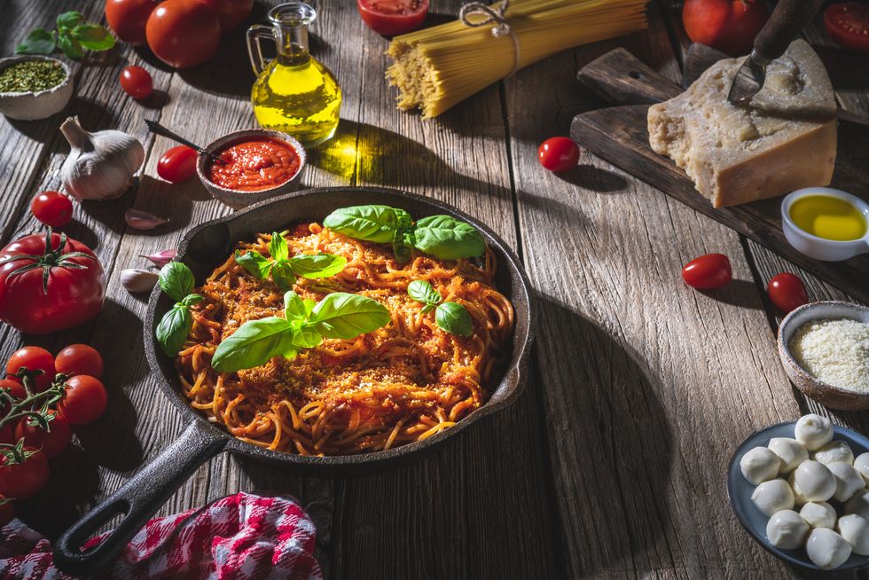 italian food pasta recipe spaghetti with tomato and ingredients on rustic wood table