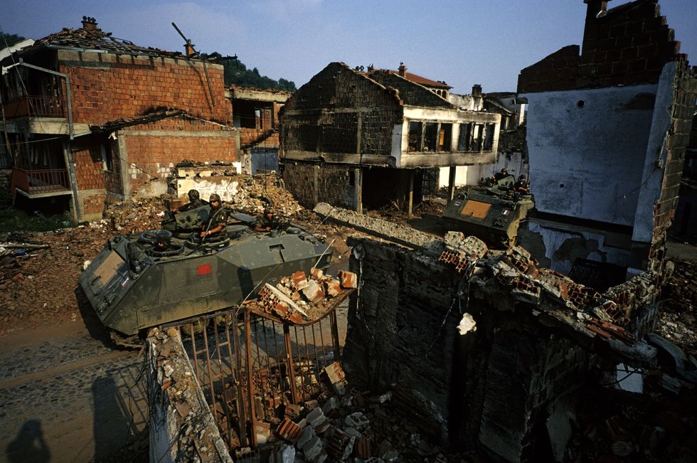italiaanse kfor militairen patrouilleren door de verwoeste straten van gjakova (kosovo) in juni 1999