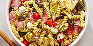 italian inspired pasta salad with cherry tomatoes, mozzarella, black olives, artichokes, and salami