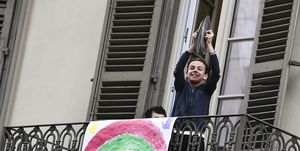 Een Italiaanse jongen op zijn balkon met twee pannendeksels om muziek te maken tijdens de lockdown in Italië vanwege coronavirus Covid-19.