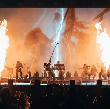 a group of people on stage with fire and smoke
