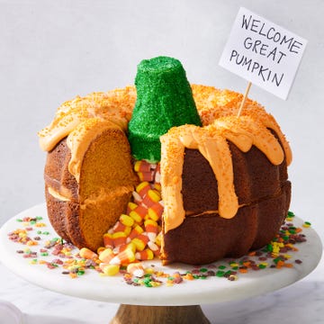 two pumpkin bundt cakes stacked on each other, filled with candy corn, and decorated to look like a pumpkin