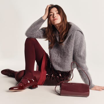 fashion model seated in stylish outfit featuring a fuzzy gray sweater and sequined burgundy skirt