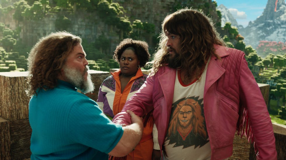 jack black and jason momoa share a manly handshake as danielle brooks looks on bemused in a minecraft movie