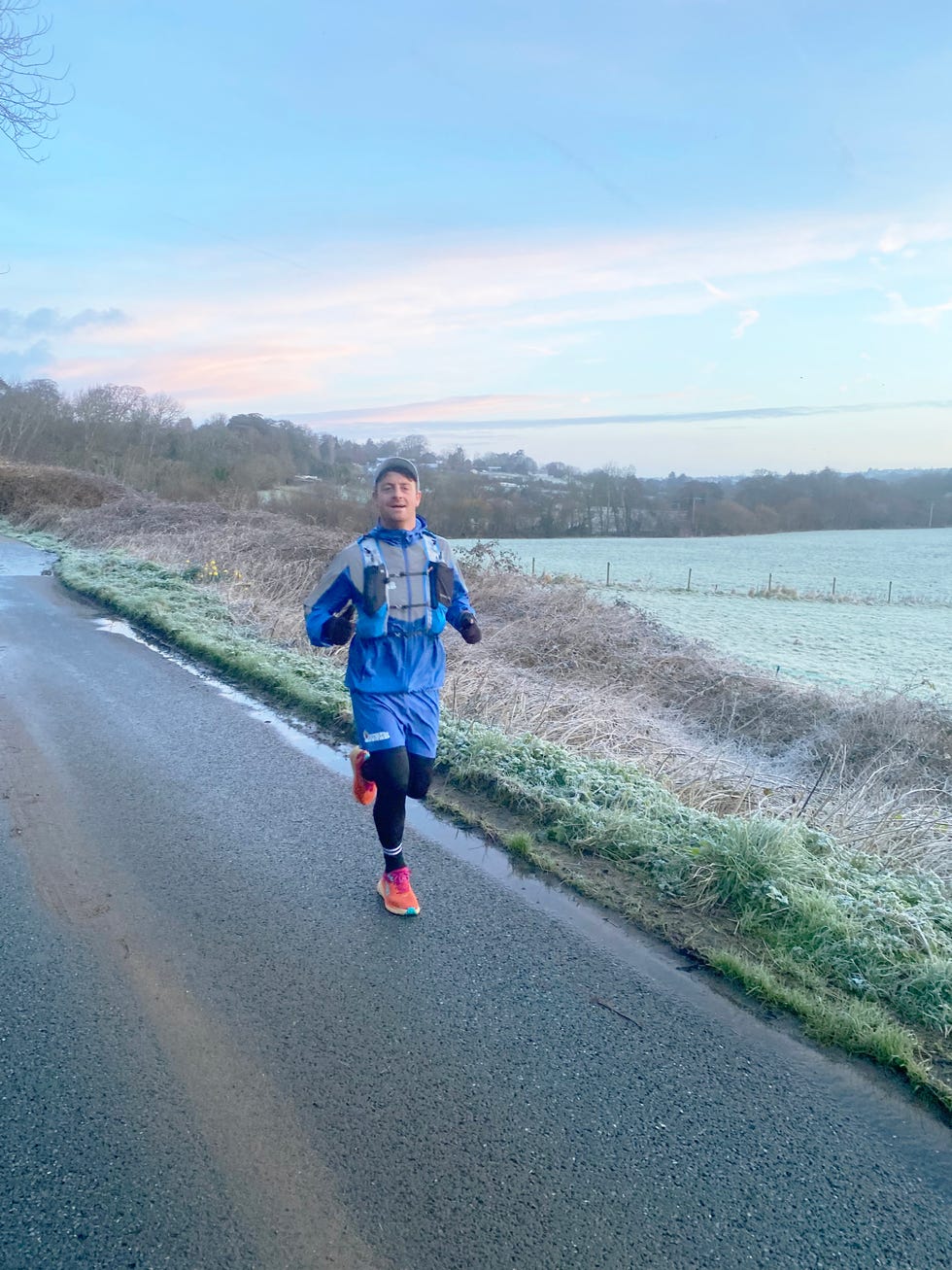 man running along a rural road in frosty weather