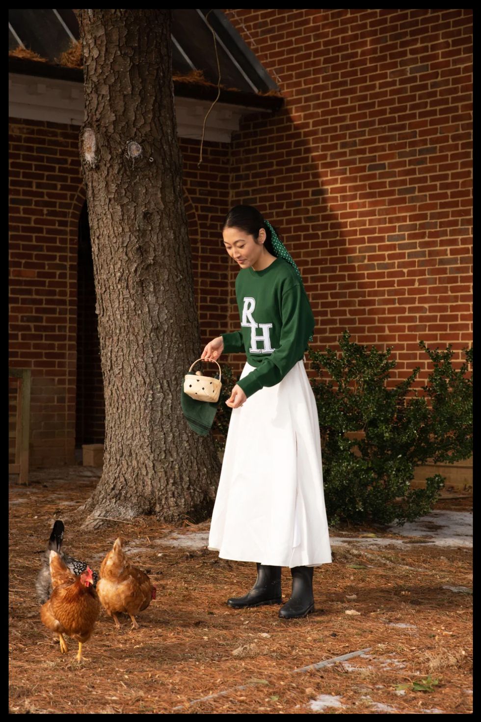 jackie skye muller of recreational habits stands in her yard feeding chickens in a roundup of style resolutions from fashion insiders 2022