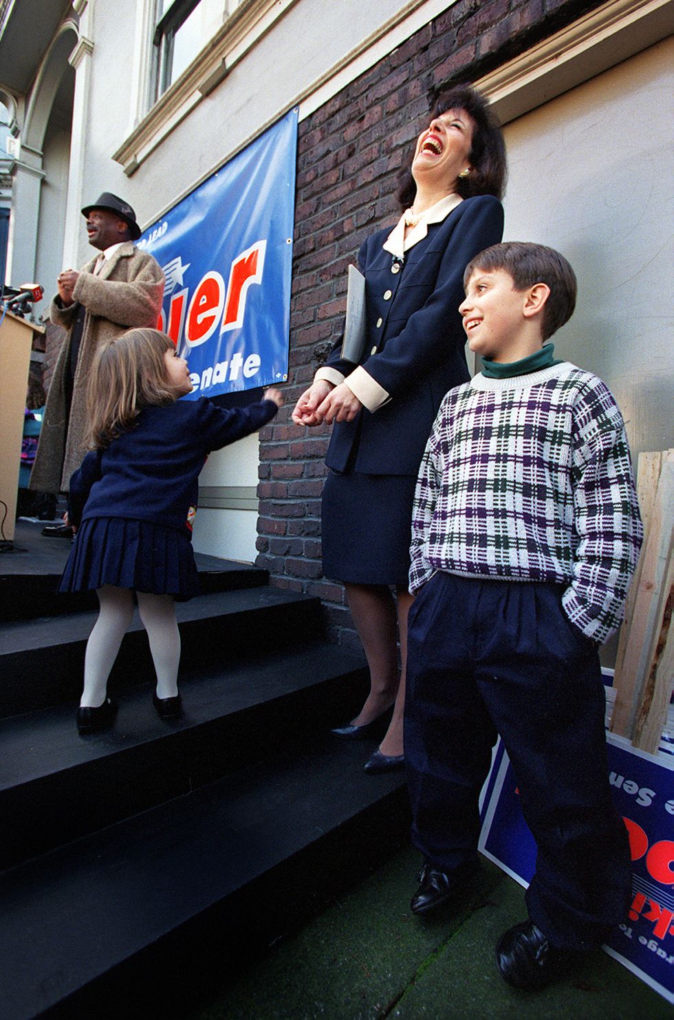 jackie speier laughing with her head tilted back with her children on either side of her