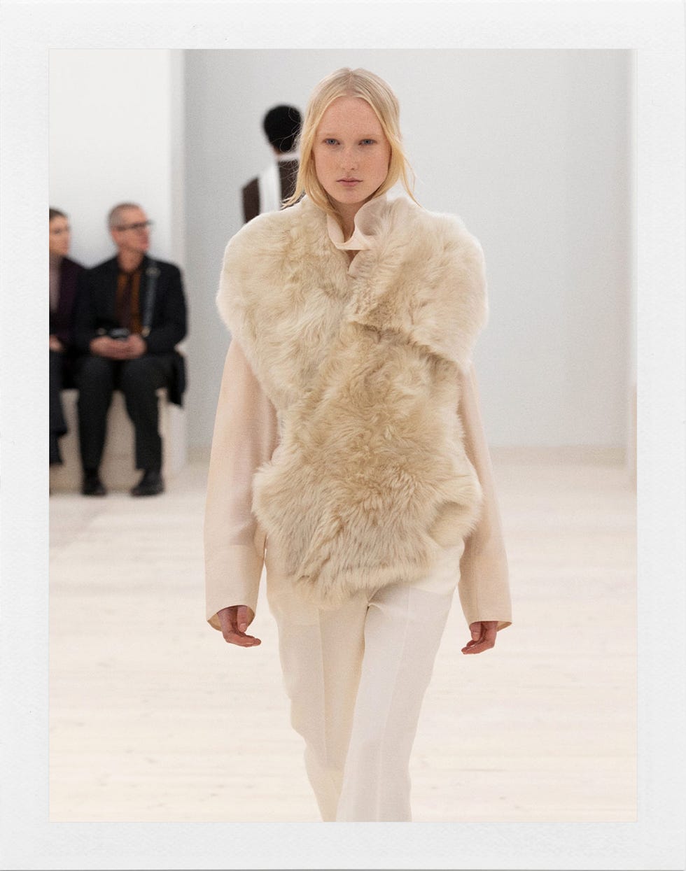 model wearing a fur vest with a soft color palette on a runway