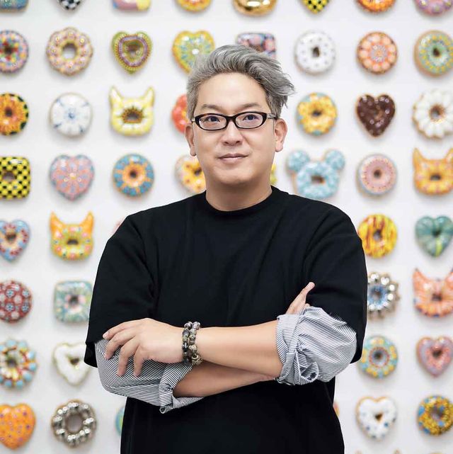 man in front of donut wall