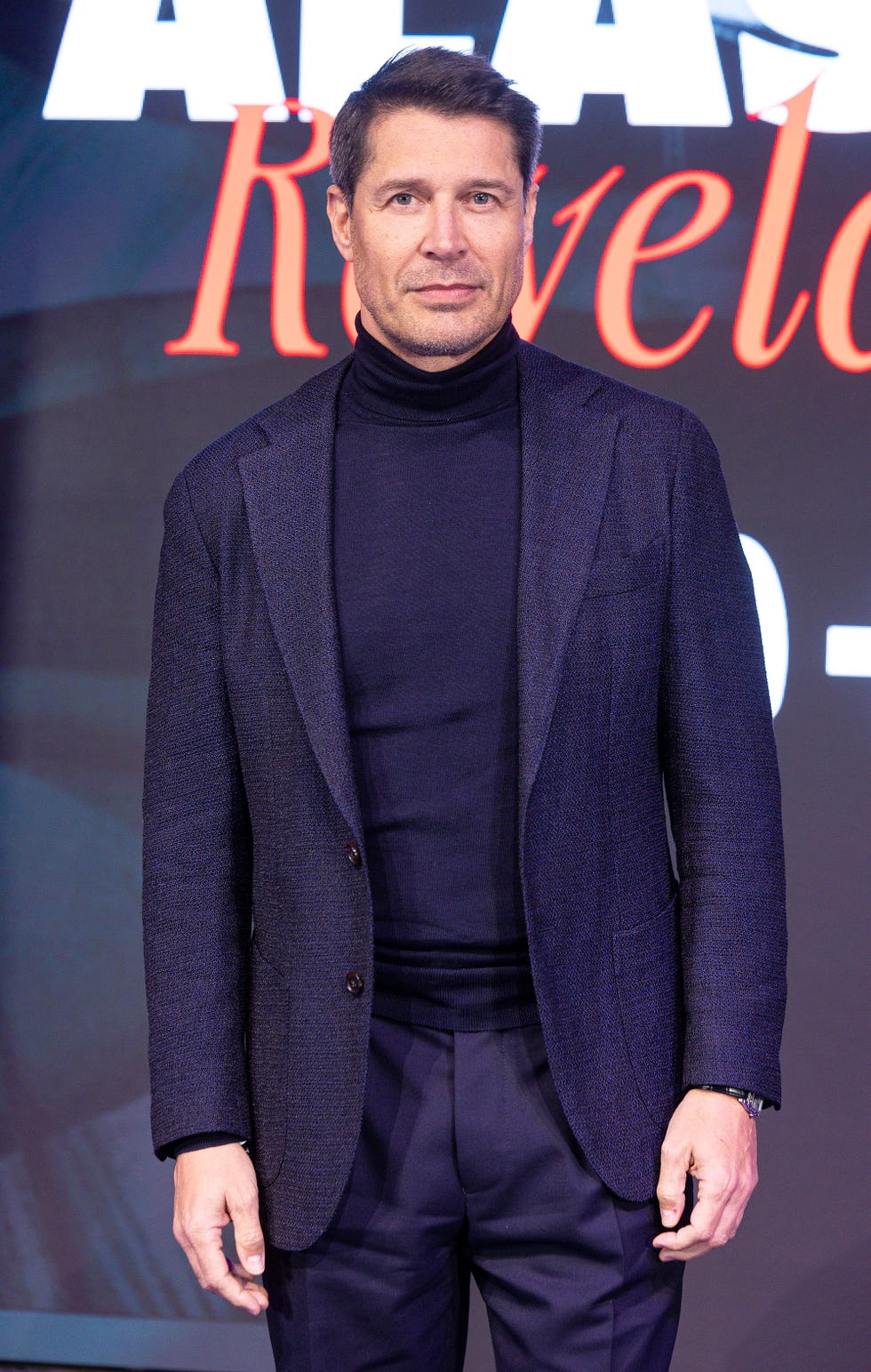 jaime cantizano con traje azul y jersey de cuello vuelto en la presentacion de la docuserie alaska revelada