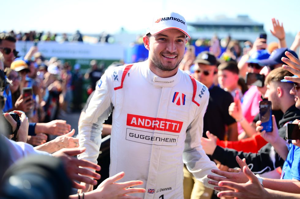 formula e driver jake dennis smiles as he walks through a crowd to the podium after a race