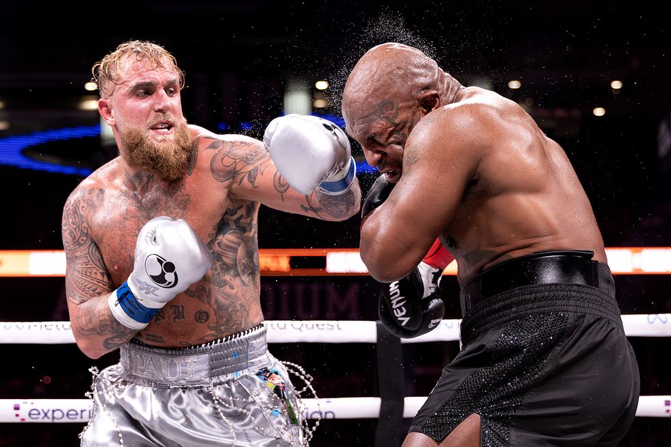 jake paul throwing a punch as mike tyson ducks