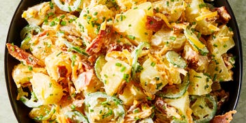 potato salad in a bowl with sliced jalapenos, bacon, and cheese