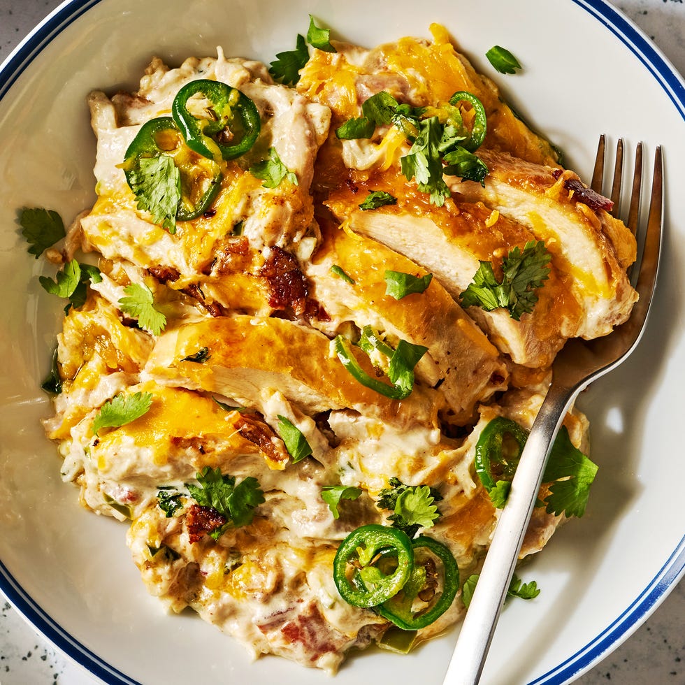 chicken in a skillet covered in cheese with jalapeños