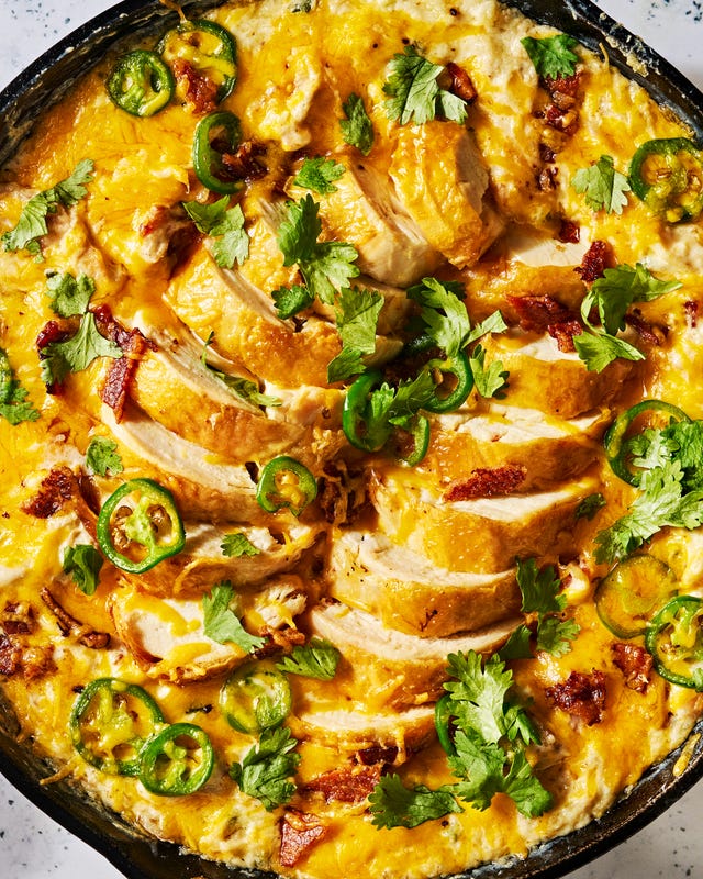 chicken in a skillet covered in cheese with jalapeños