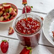 glass of strawberry rhubarb jam on breakfast table