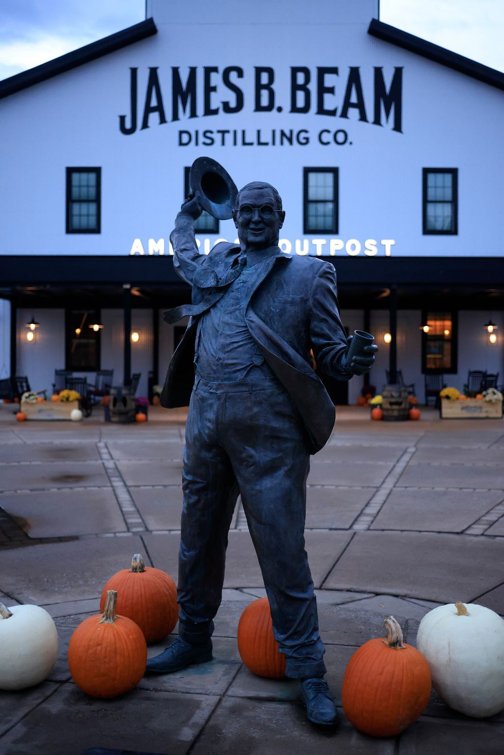 a statue of jim beam with pumpkins outside the american outpost store at james beam distillery co