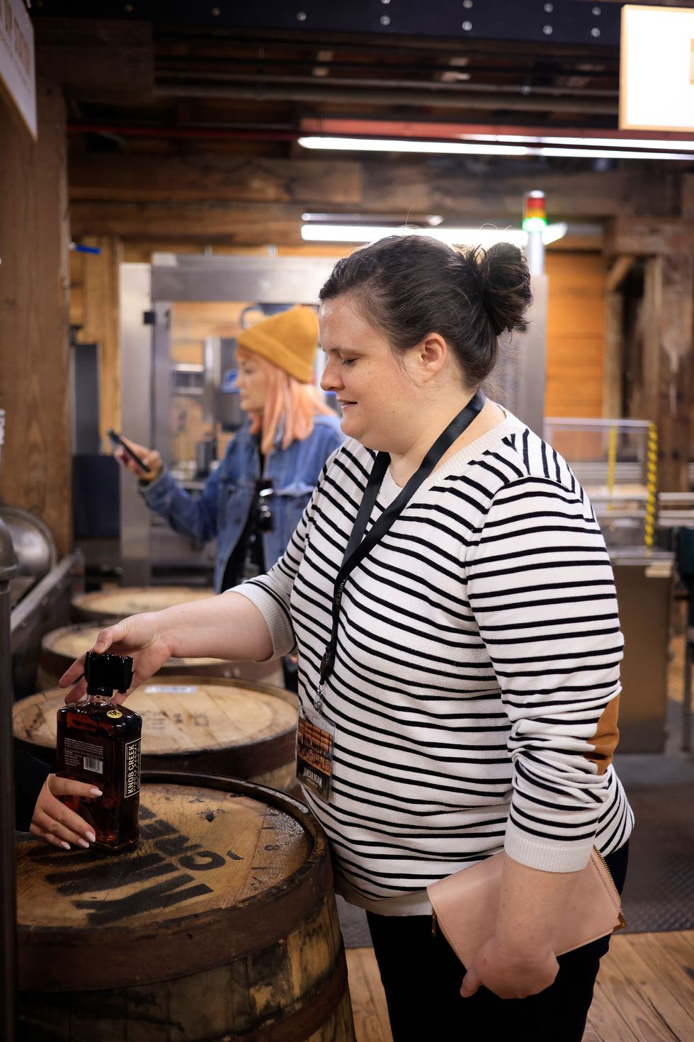 the author putting her thumbprint in the hot wax seal of a bottle of knob creek bourbon on a tour of the james b beam distillery co