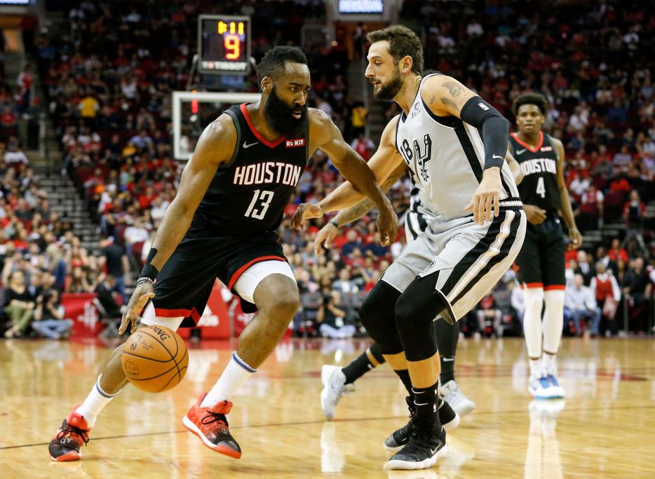 james harden dribbling a basketball in front of a defender during an nba game