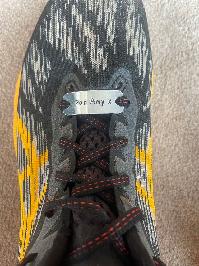 a closeup of a running trainer with a name tag reading amy