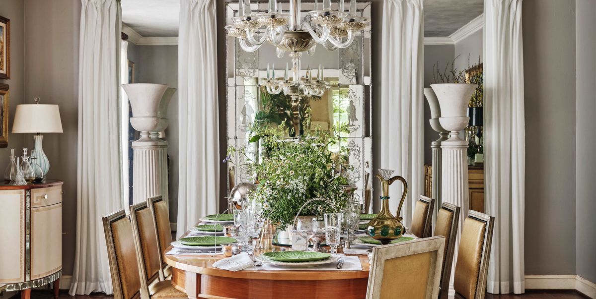 beneath a murano glass chandelier wildflowers flourish in pretty garden pots in a dining room