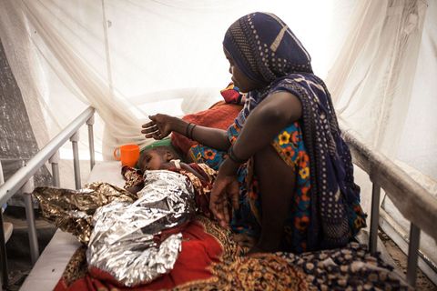 Babay Moussa 23 wuift Abakar 2 koele lucht toe in een kliniek van het International Rescue Committee in Liwa Tsjaad Het kind lijdt aan een longziekte die is verergerd door ondervoeding Veel binnenlandse ontheemden zijn naar de dorpen rond Liwa gevlucht Hun families komen oorspronkelijk uit dit gebied dat zich ooit op het meer bevond en hebben de wijkende oevers decennialang gevolgd Naarmate de Boko Haramcrisis zich over de grens verplaatste keerden velen die aan het meer woonden terug naar deze veilige geboorteplaatsen