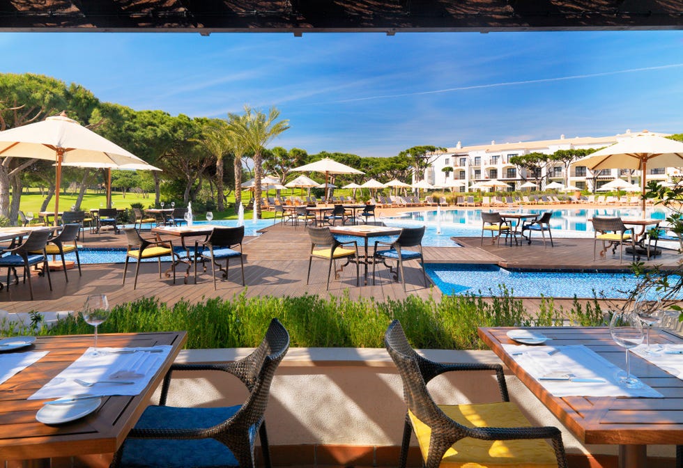 a pool with tables and chairs next to it