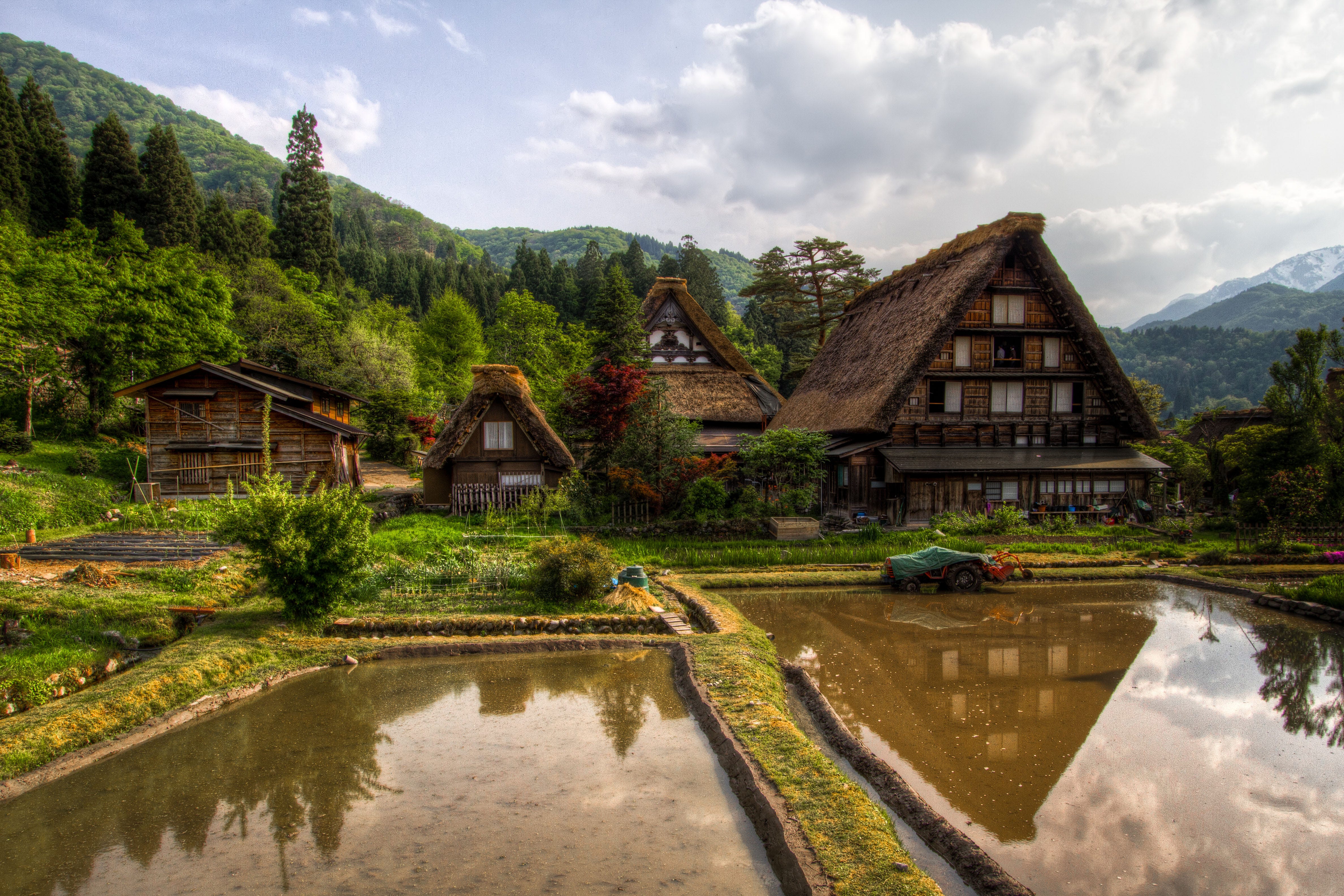 reflection of farmhouses with trees and landscape in background