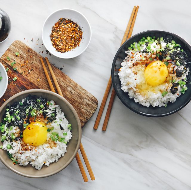 overhead shot of bowls of Asian cuisine with rice and chopsticks