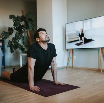 japanese man taking online yoga lessons during lockdown in isolation