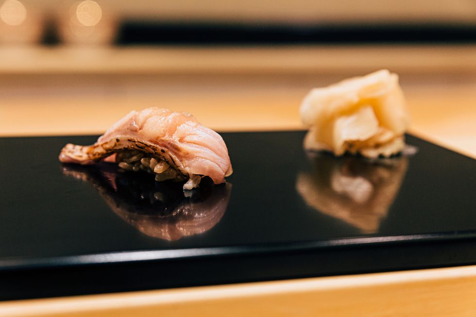 japanese omakase meal yellowtail amberjack sushi served by hand with pickled ginger on glossy black plate japanese traditional and luxury meal
