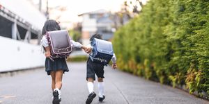 japanese schoolchildren holding hands and running