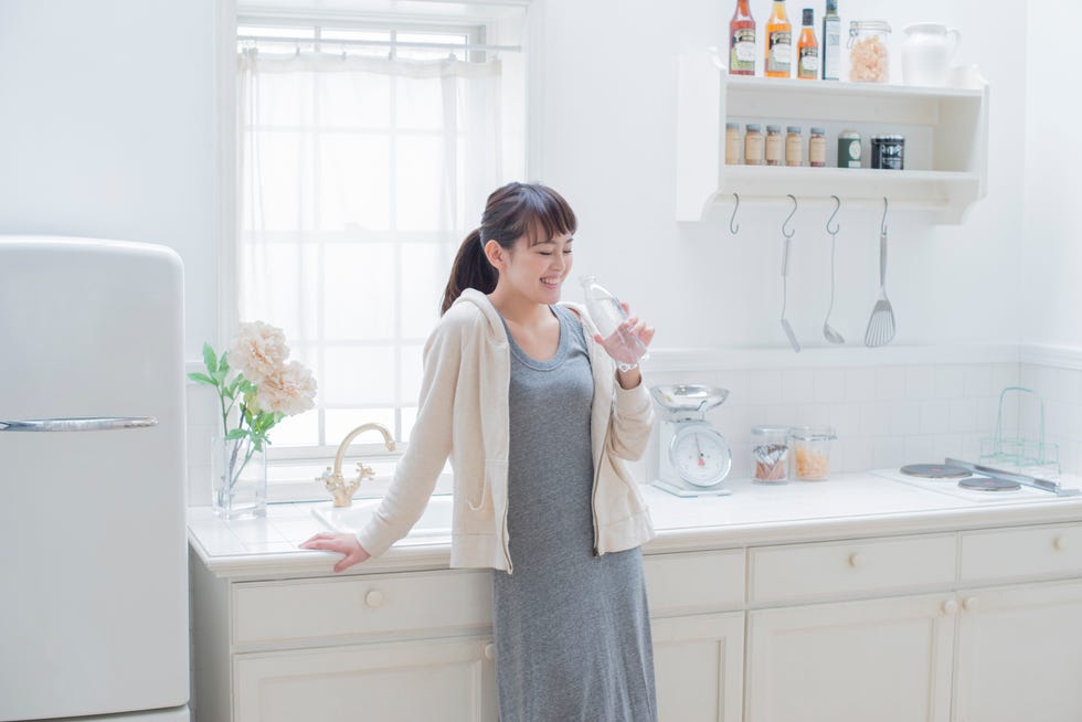 Japanese woman drinking a bottle of water.