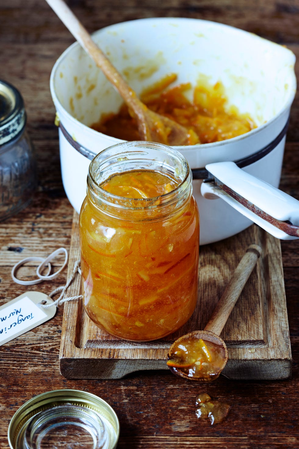 a jar of homemade marmalade on table with pan