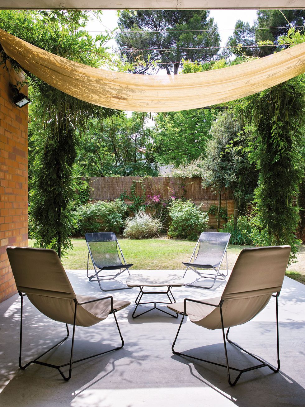 garden with seating area with sun loungers under an awning