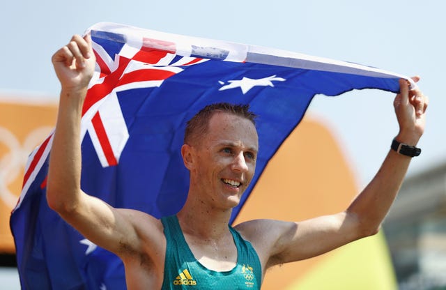 jared tallent celebra una medalla olímpica en marcha debajo de una bandera de australia