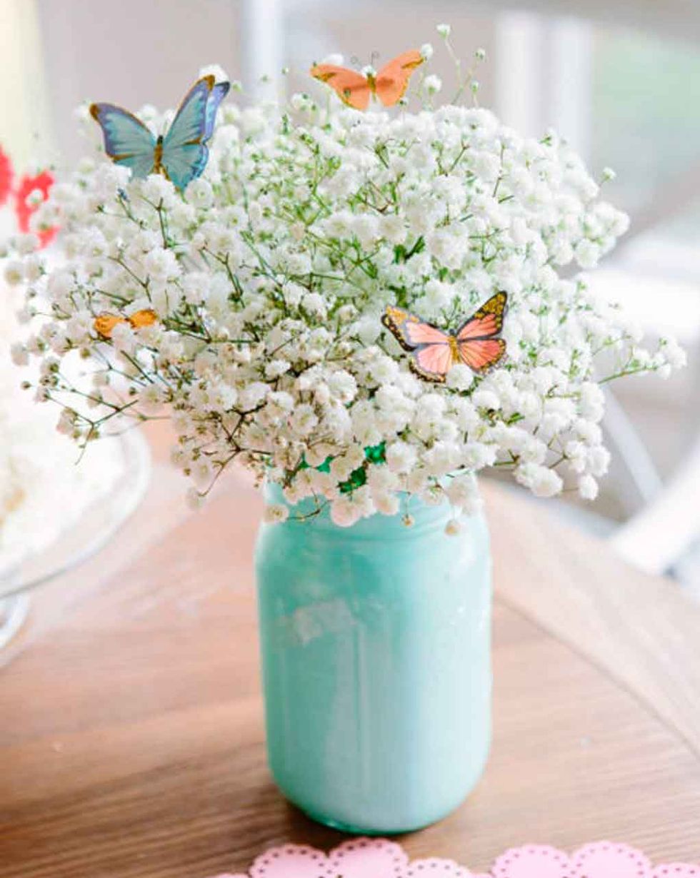 un centro de flores blancas y mariposas para pascua