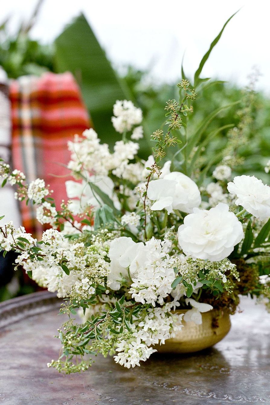 Flores artificiales en jarrones de cerámica blanca sobre la decoración de  la mesa.