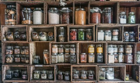 jars containing spices and herbs in diy wooden rack