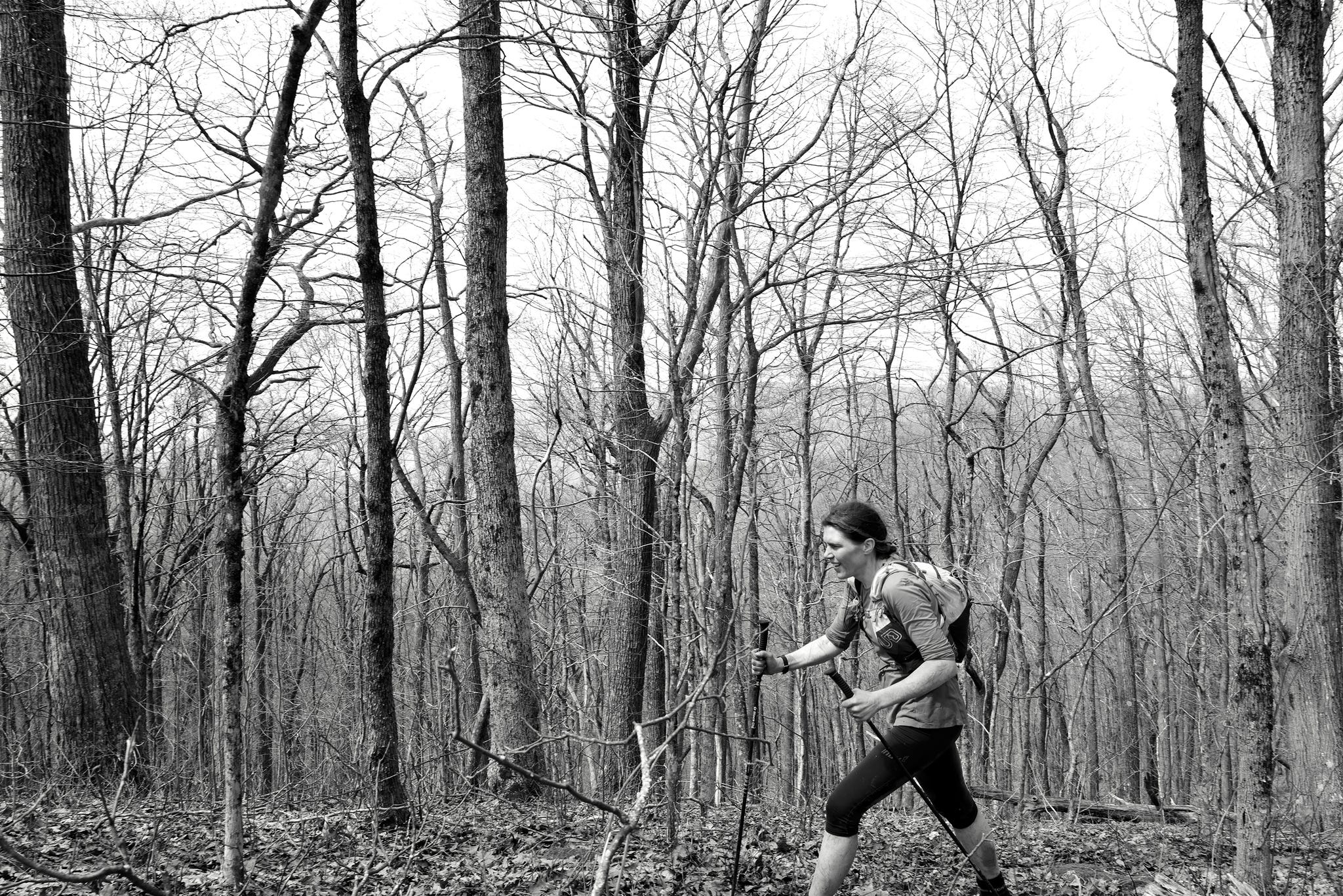 a woman hikes through rough woodland