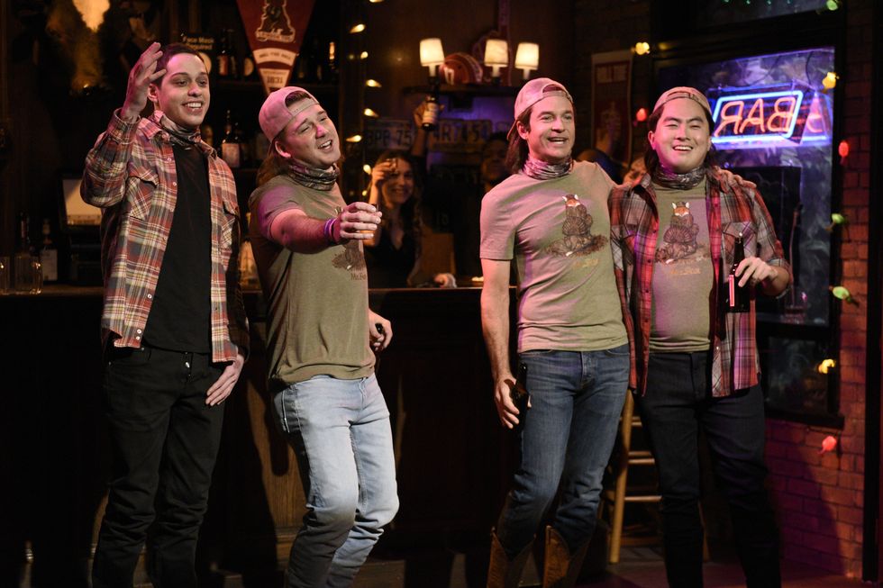 morgan wallen smiling and singing during a segment with snl actors