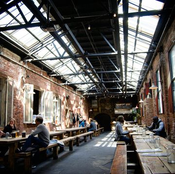 people sitting at tables in a brick building