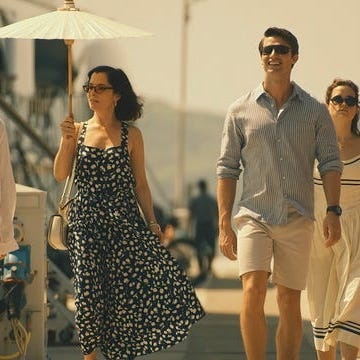 group of people walking along a waterfront promenade group of people walking along a waterfront promenade