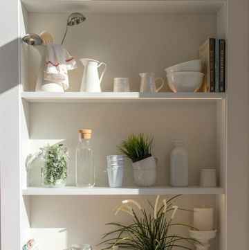 a white shelving unit with white shelves and plants
