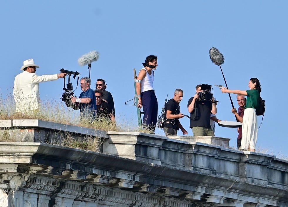 jason momoa and gal gadot point guns while oscar isaac is gagged and bound while filming in the hand of dante in venice